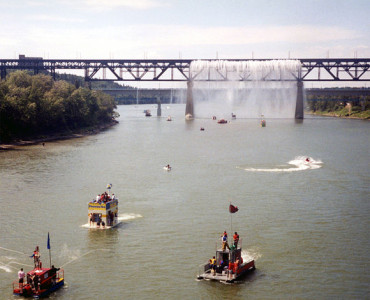 The 2001 Sourdough Raft Race, passing beneath the High Level Bridge's Great Divide waterfall during Klondike Days.